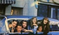 a group of young people hang their windows outside of a car